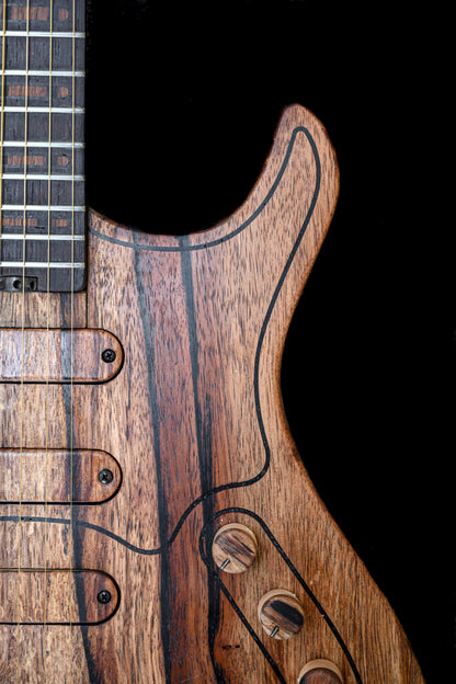Gros plan sur la guitare de la série M de Belforti Instruments, mettant en évidence les détails du grain du bois et des composants matériels.