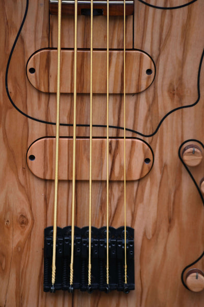 Gros plan sur la Vēa 5 - Guitare basse Masterbuilt de Belforti, qui met en valeur des bois de qualité supérieure et un savoir-faire artisanal.