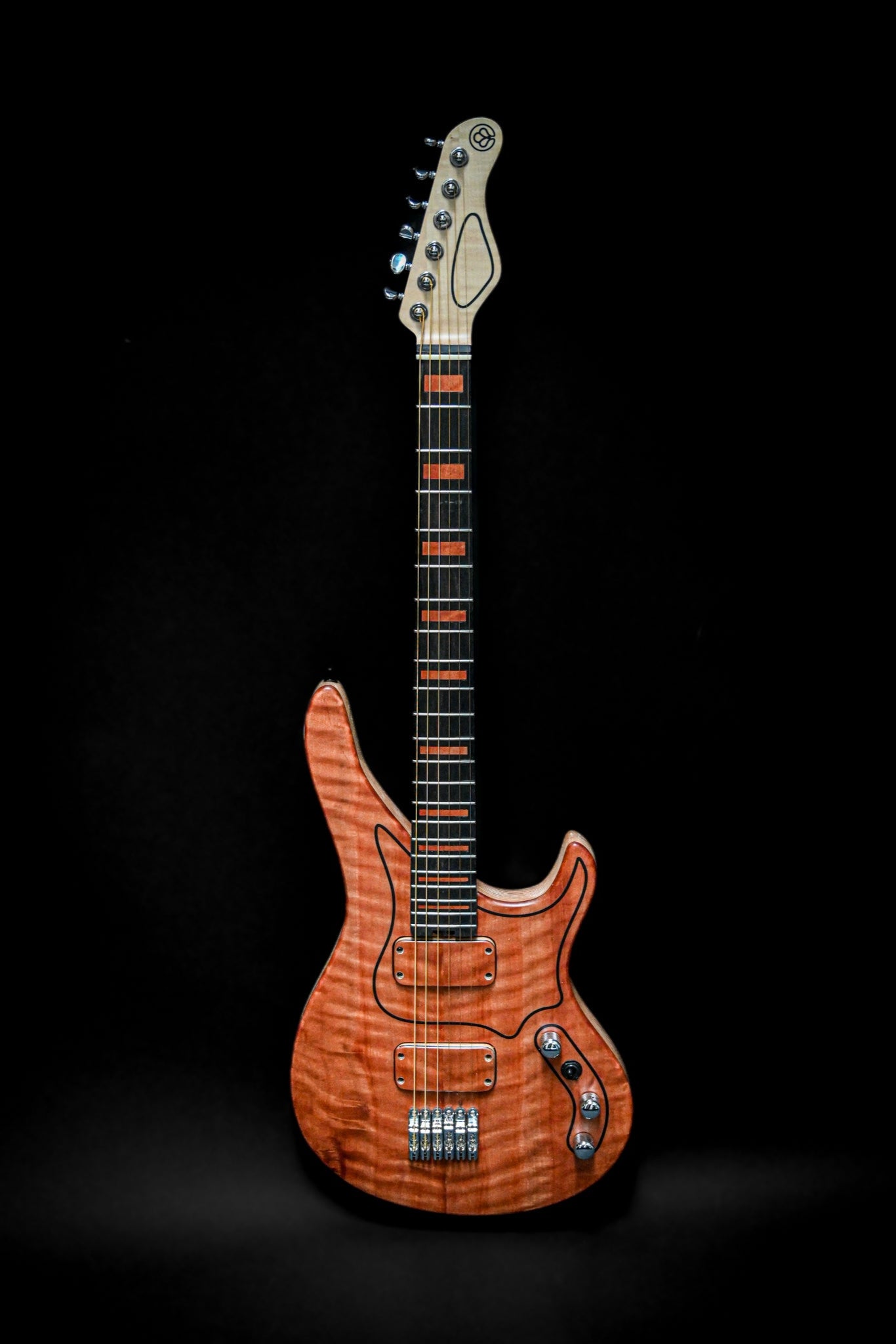 M7 - La guitare avec une table en Makore est présentée sur un fond noir, mettant en valeur son design et sa fabrication uniques.