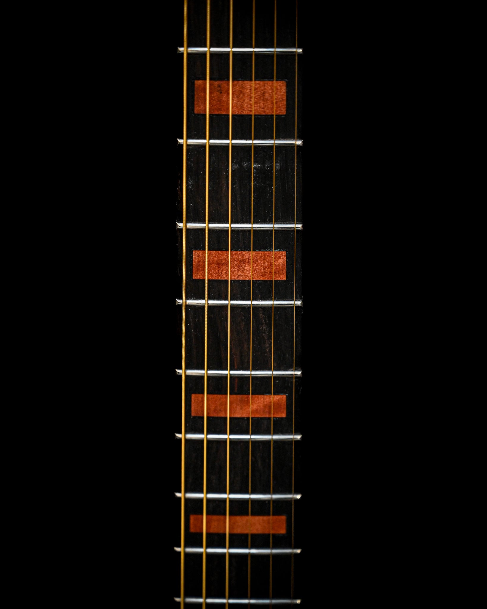 Gros plan sur le dos de la guitare M7 - Makore, mettant en évidence les veines du bois et les éléments structurels.