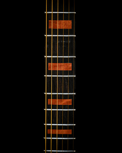 Gros plan sur le dos de la guitare M7 - Makore, mettant en évidence les veines du bois et les éléments structurels.
