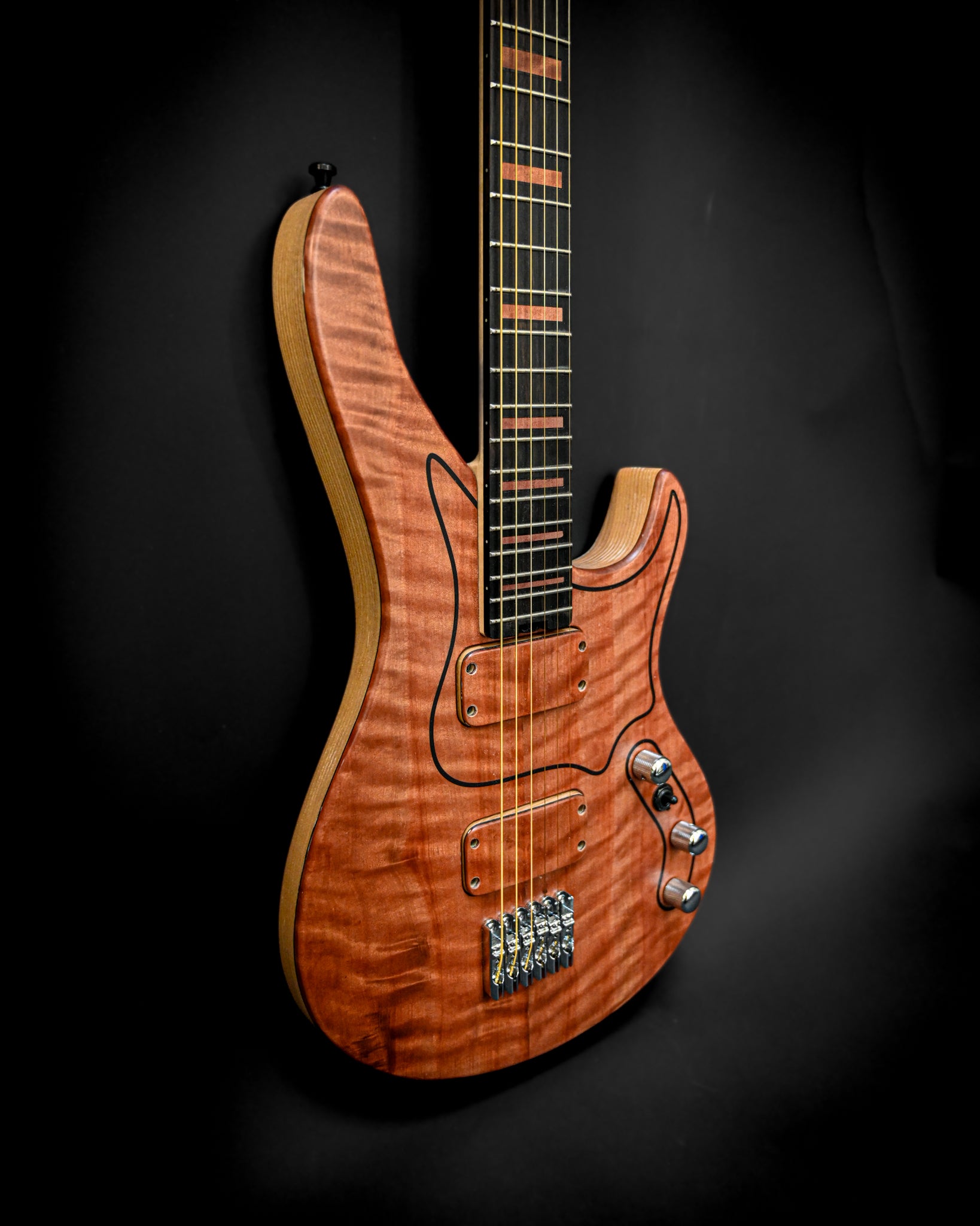 Un autre angle de la guitare M7 - Makore, mettant en valeur sa riche finition en bois et ses détails complexes.