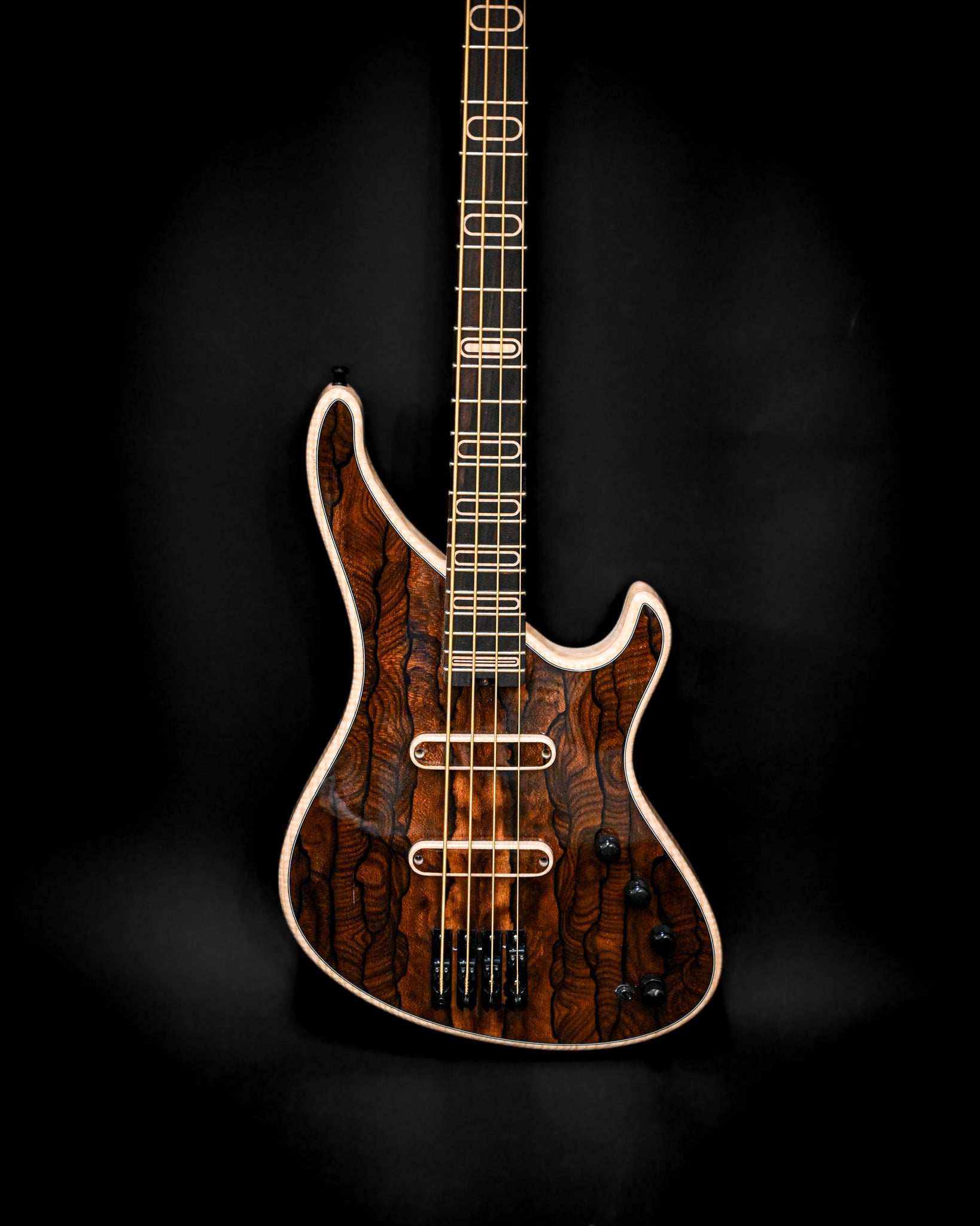 Vue latérale de la guitare basse électrique S1 Ziricote mettant en valeur sa forme unique et ses riches détails en ziricote.