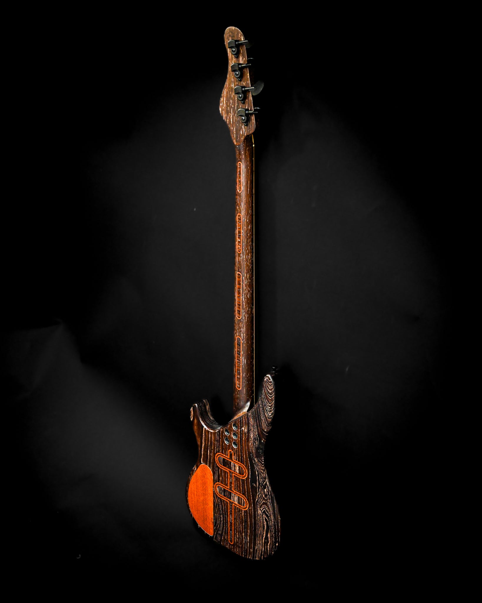 Gros plan sur le dos de la guitare basse électrique S3 Lacewood, mettant en valeur la richesse des textures et des détails.