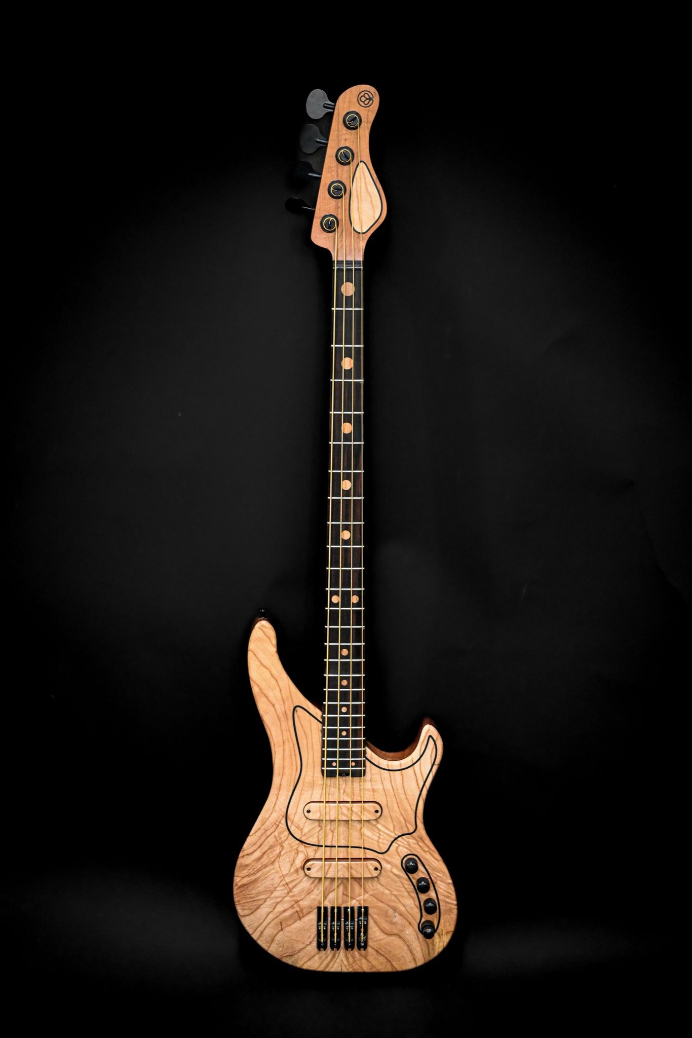 Guitare basse M3 Maple avec table d'harmonie en érable figuré, mettant en valeur son design épuré sur fond noir.
