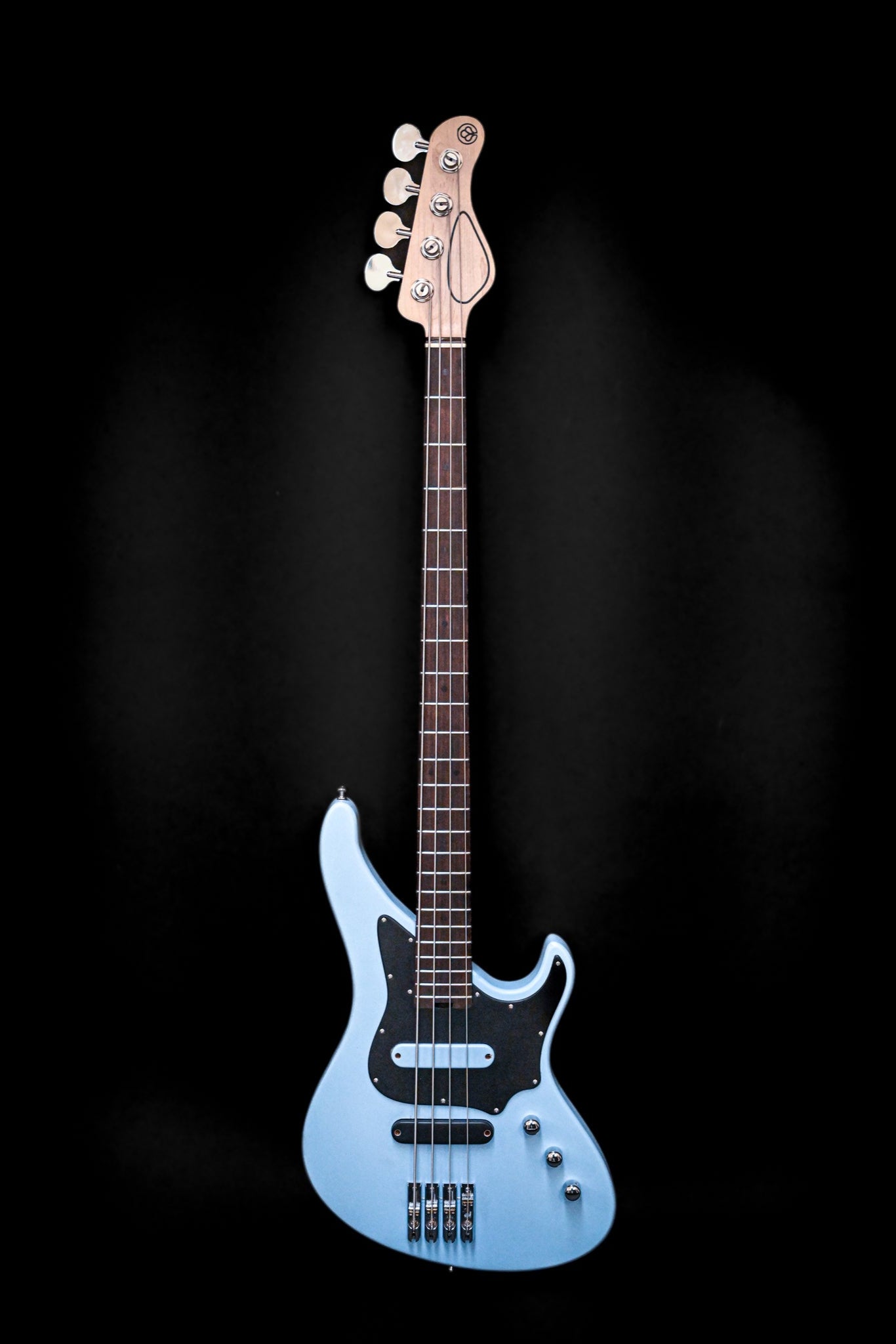 La guitare basse à 4 cordes E1 Siberian Frost de Belforti Instruments présente un design élégant avec une finition bleu clair sur fond noir.