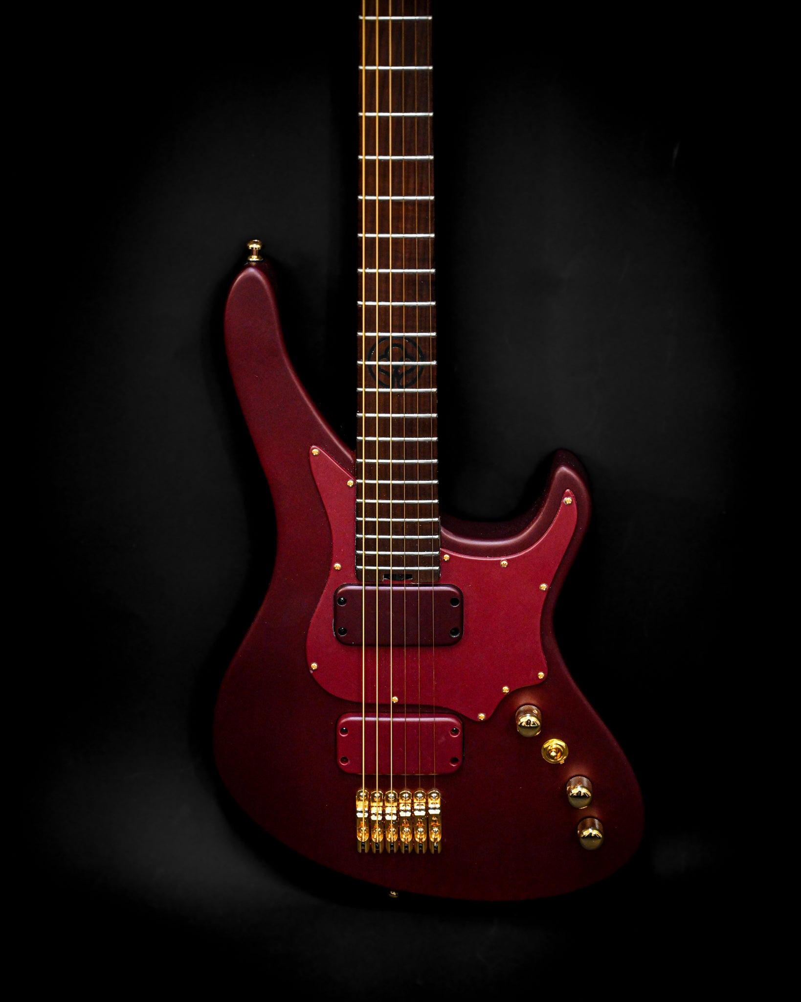 Vista em grande plano da guitarra eléctrica E5 Aventurinrot, realçando o seu acabamento vermelho rico e as ferragens douradas.