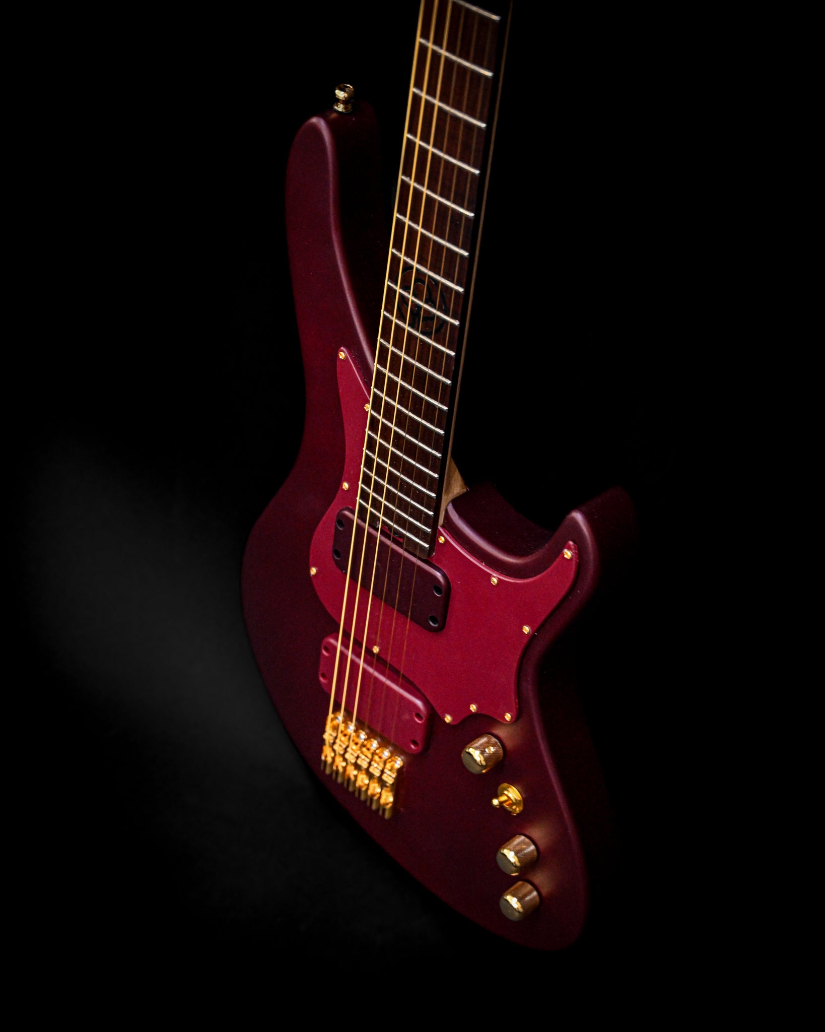 Ângulo artístico da guitarra E5 Aventurinrot exibindo a sua cor Aventurinrot arrojada e caraterísticas intrincadas.