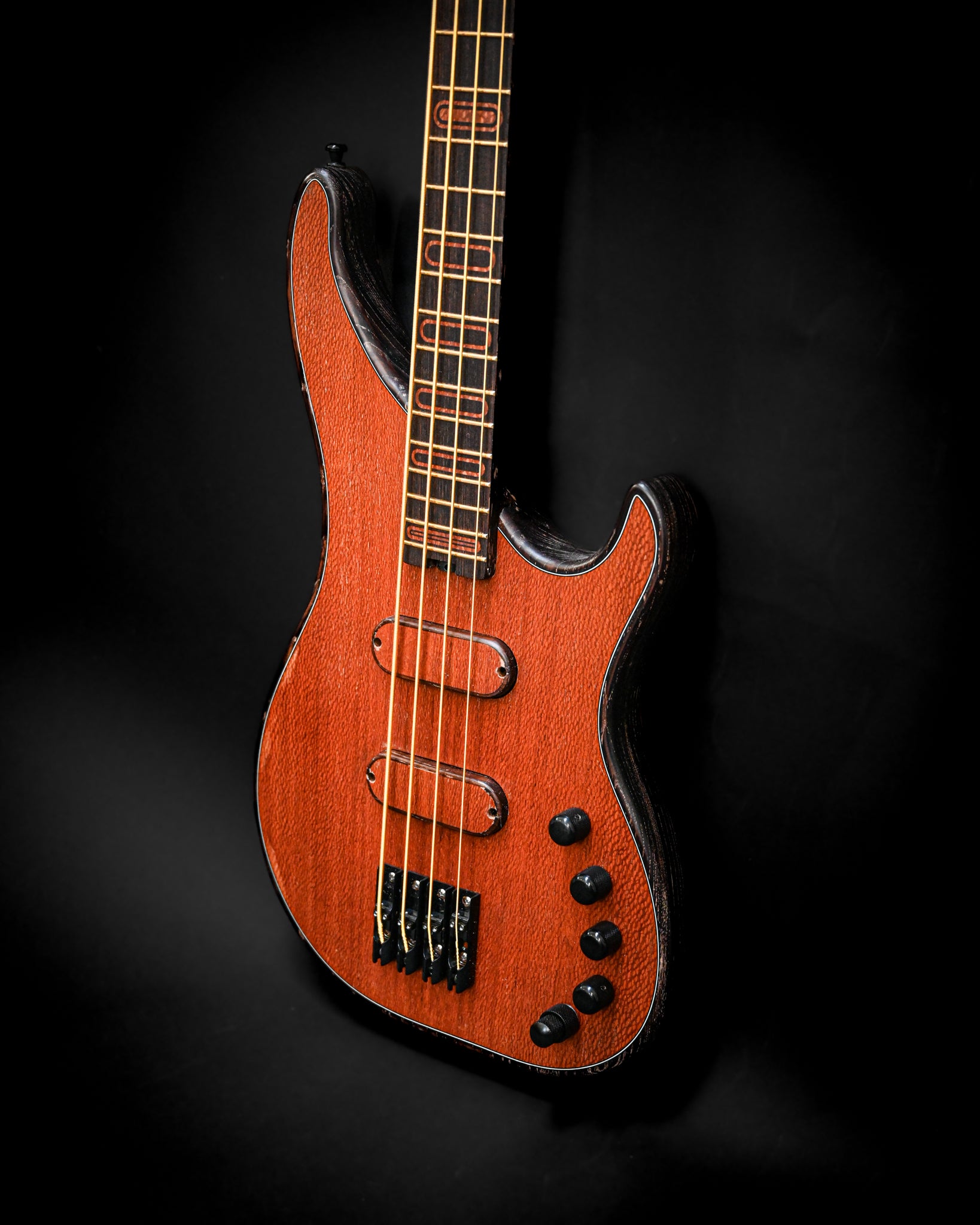 Vista distinta da guitarra baixo S3 Lacewood, focando as curvas e a cor do corpo.