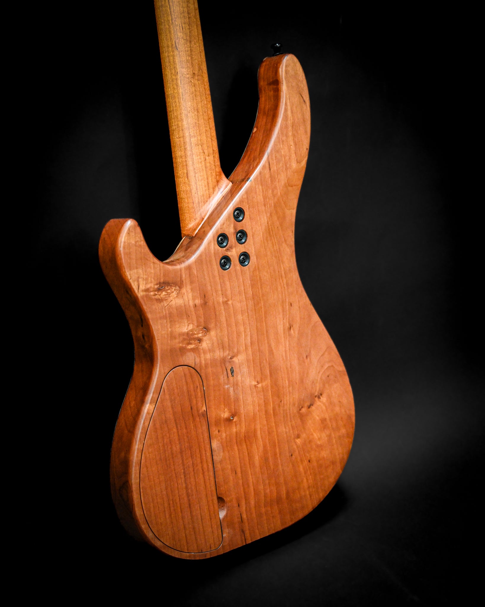 Ângulo traseiro detalhado do baixo M3 Maple, destacando o seu formato elegante e os seus componentes eletrónicos.