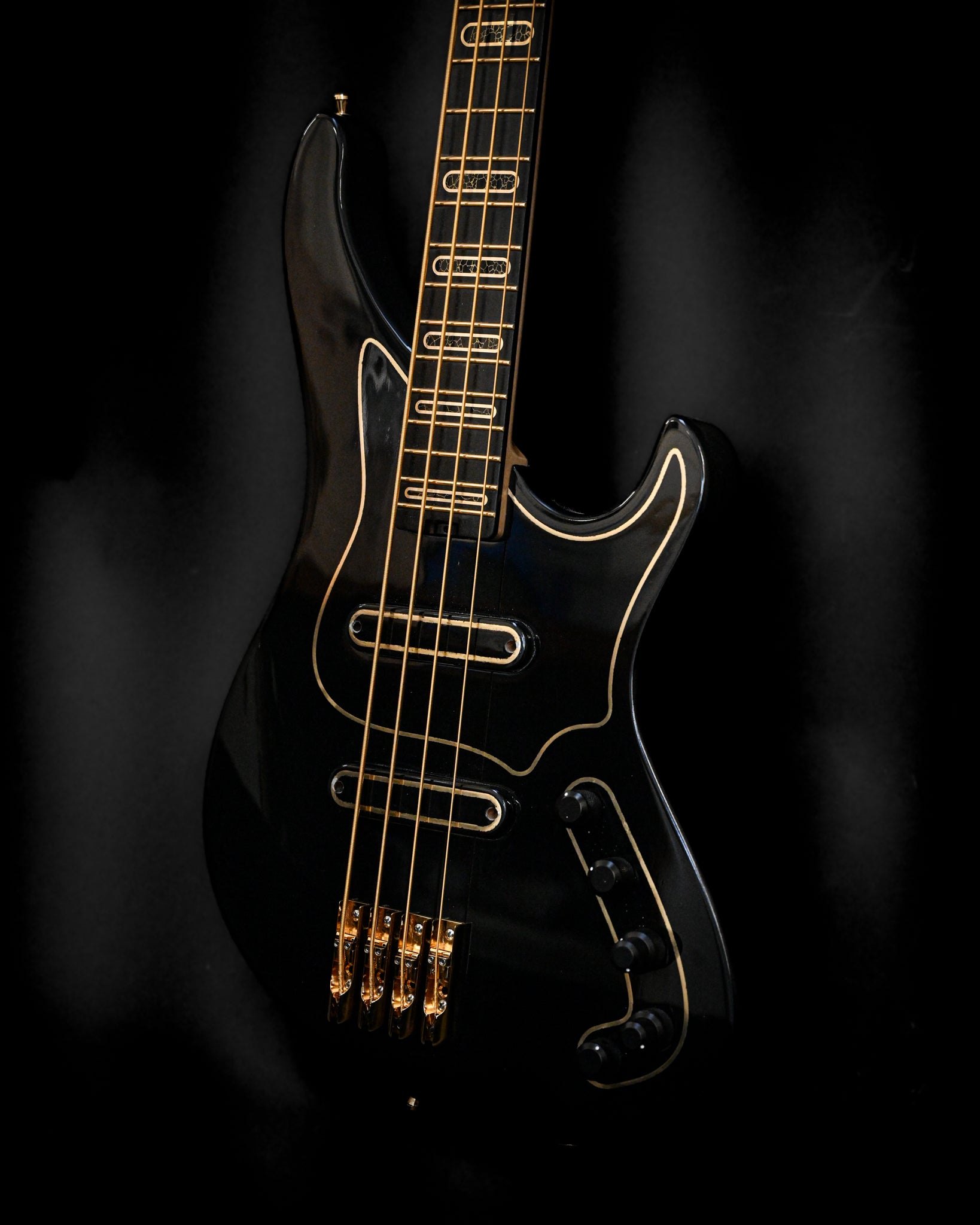 Fotografia artística da guitarra baixo S1 'Laudate Concordia' Limited Edition, realçando a forma do corpo e o acabamento preto rico.