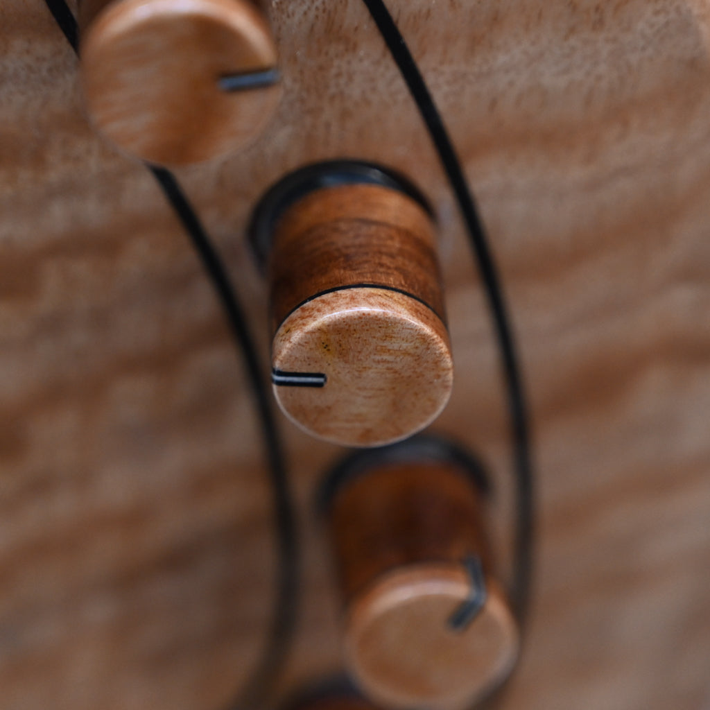 Belforti Instruments M3 Flamed Eucalyptus 低音吉他调音装置的详细特写，突出了独特的木质装饰。