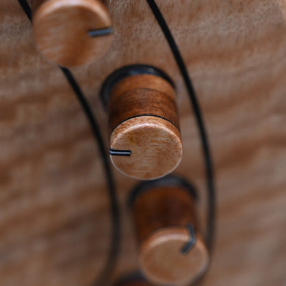 Belforti Instruments M3 Flamed Eucalyptus 低音吉他调音装置的详细特写，突出了独特的木质装饰。