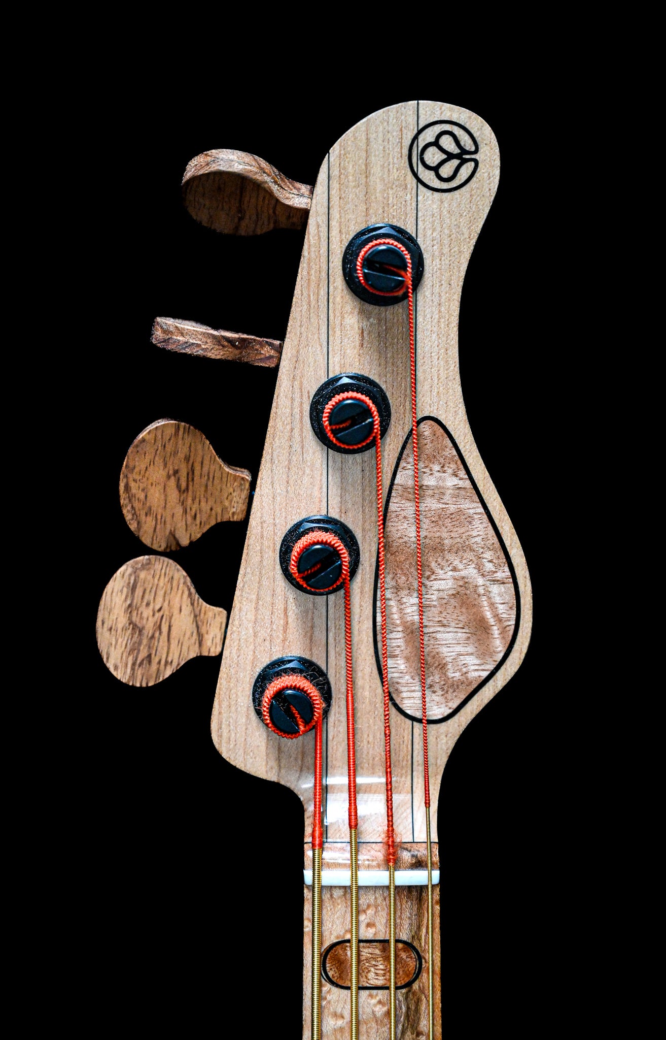 Belforti Instruments M3 Flamed Eucalyptus 低音吉他的琴头，配有调音钉和签名设计。