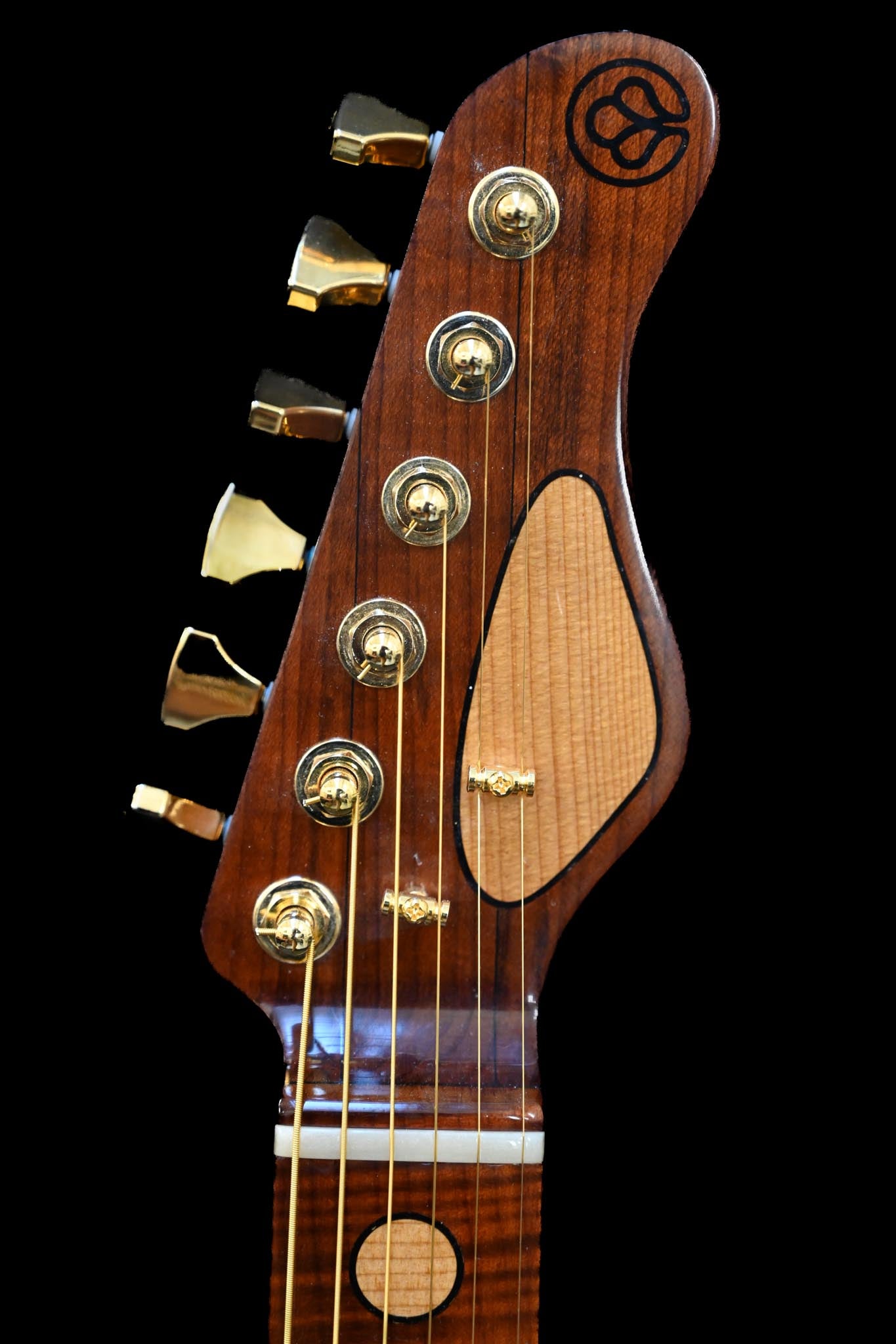 Belforti Instruments M7 Heritage 红雪松木吉他的琴头，饰有金色音栓和品牌徽标。