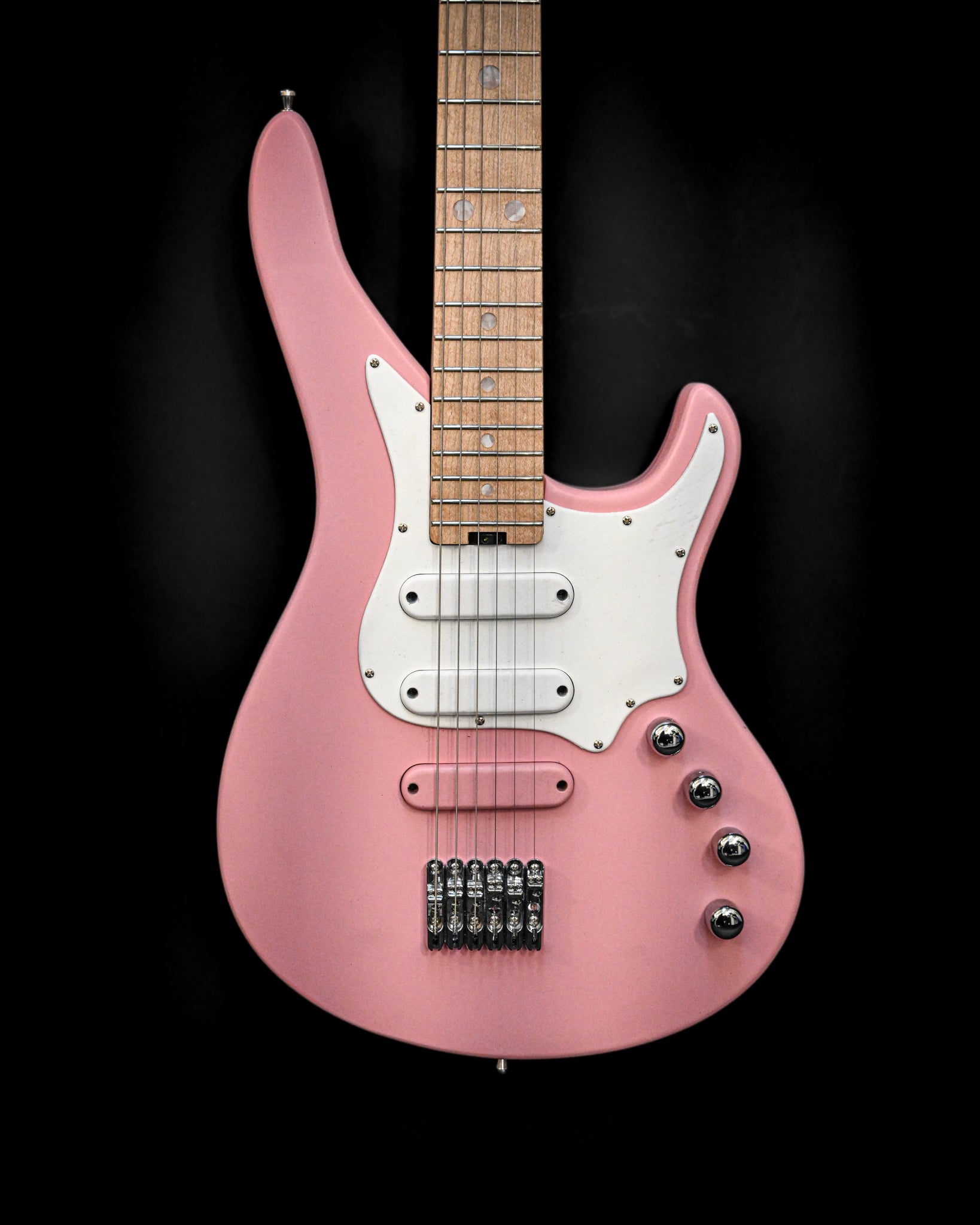 E7 Ueno Sakura Pink 吉他特写，黑色背景下的琴身和拾音器。