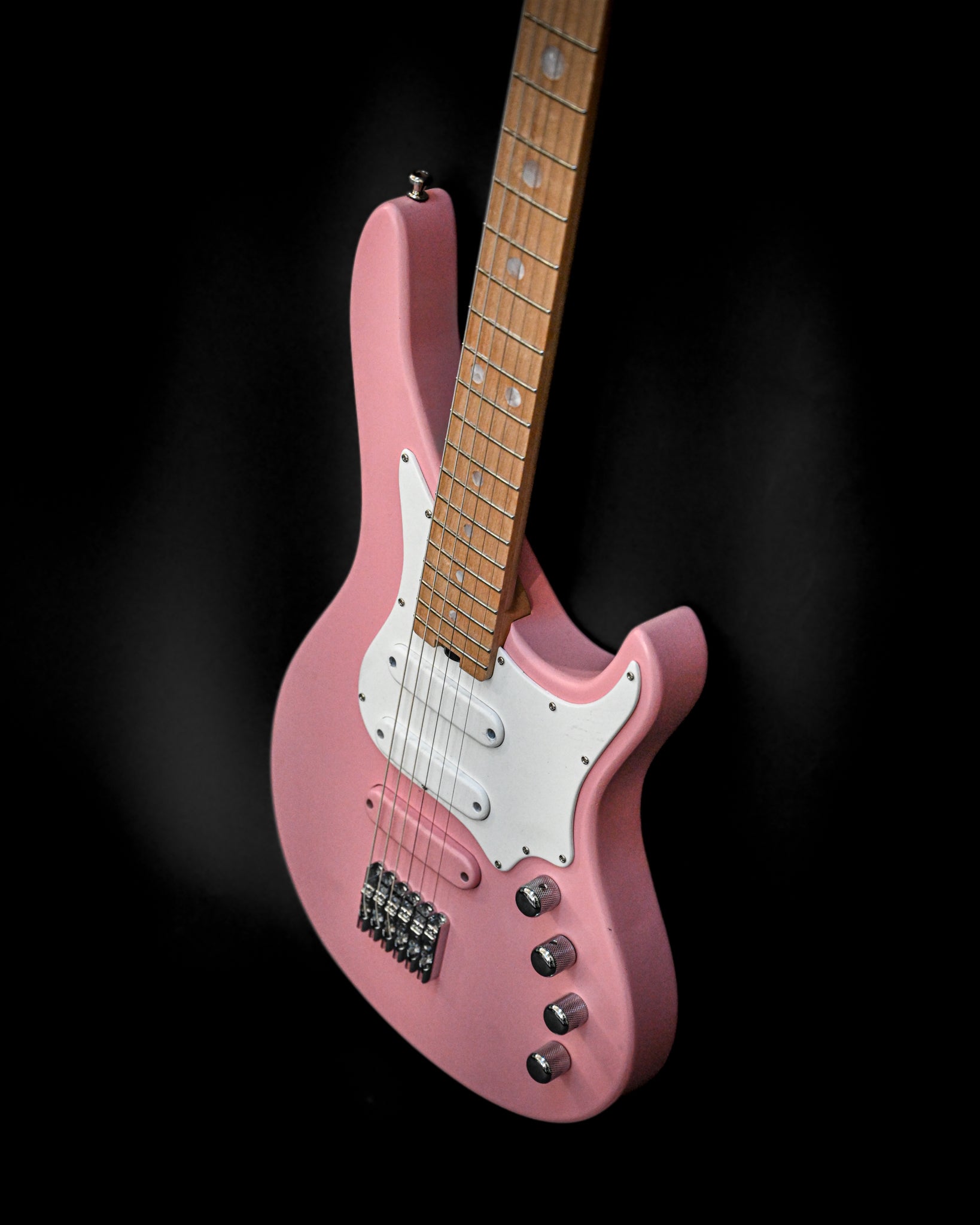 E7 Ueno Sakura Pink 吉他的斜视图，强调其纤细的外形和指板。