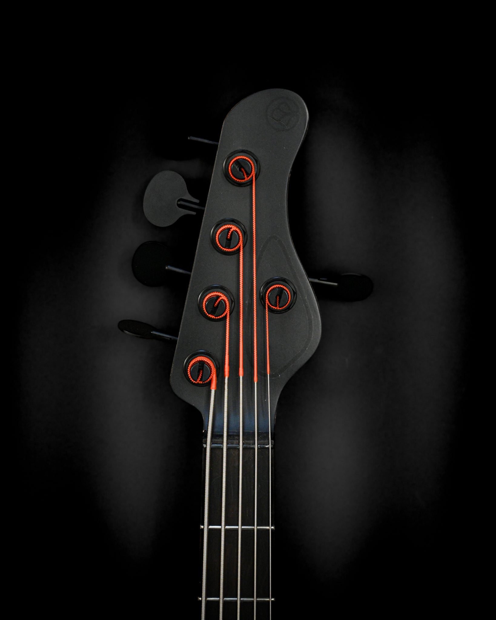 Belforti Instruments E3 Lorraine Coal 低音吉他琴头特写，音栓上有鲜艳的橙色装饰。