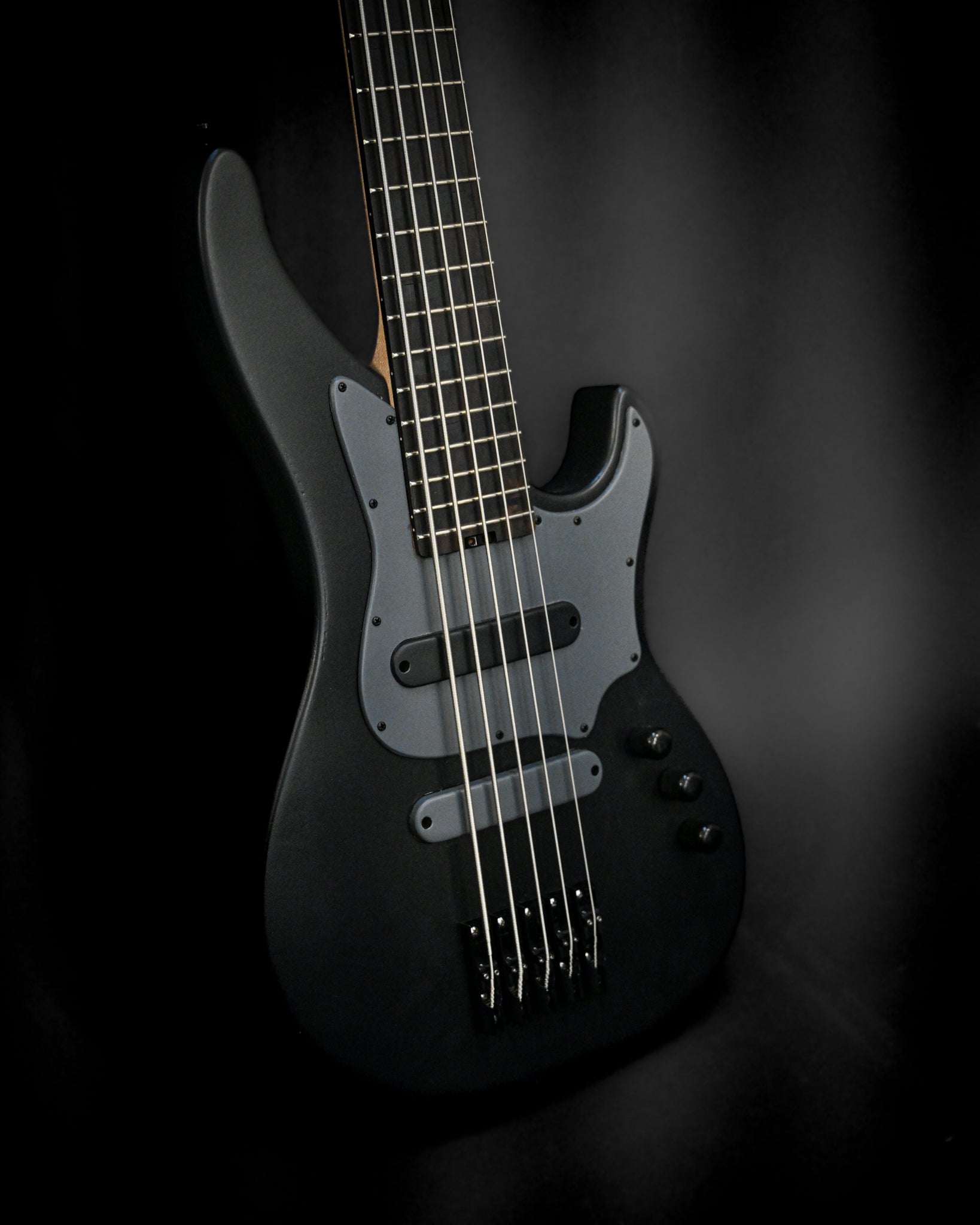 Belforti Instruments 的 E3 Lorraine Coal 低音吉他在深色背景下展示琴身和琴弦。