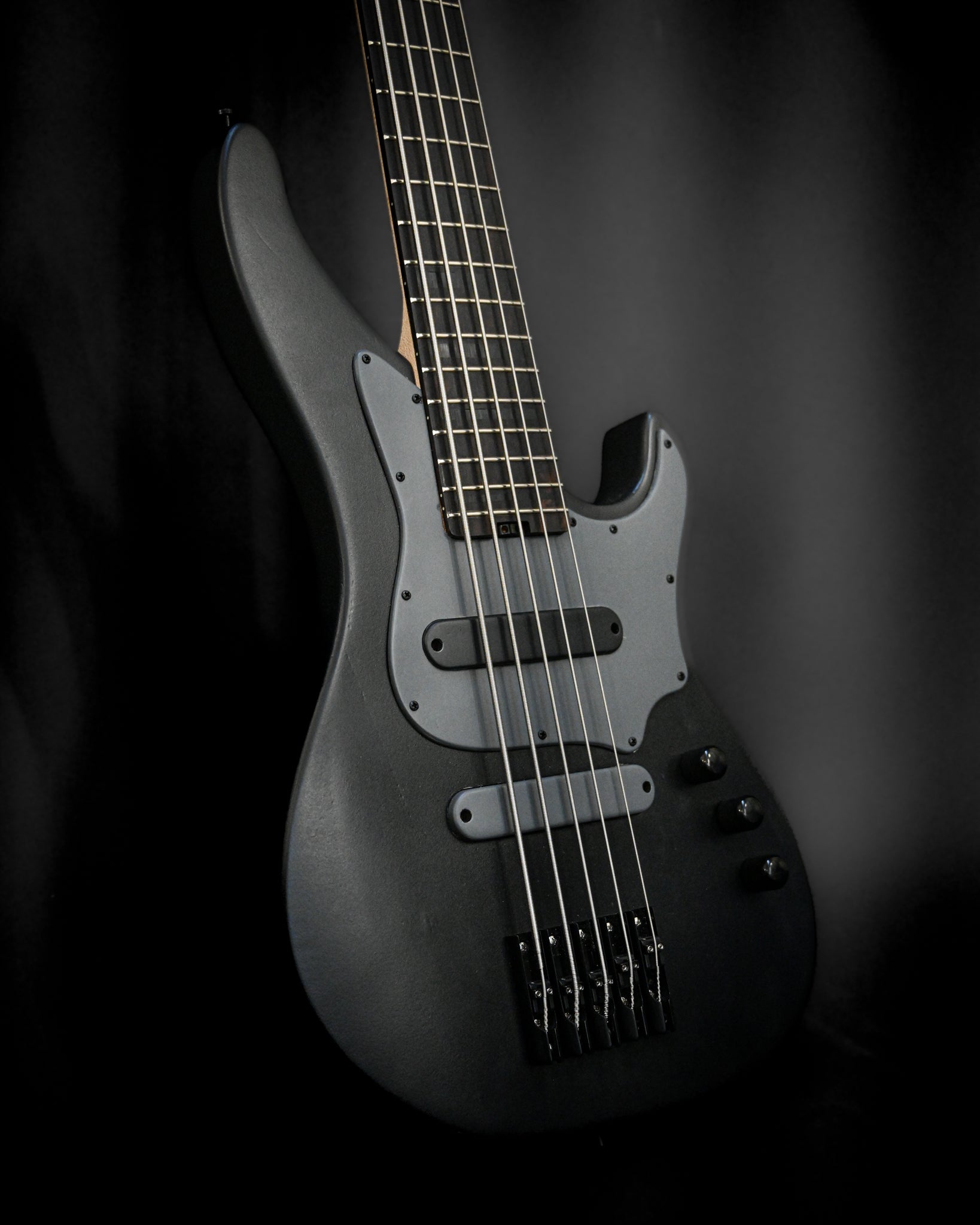 从一个独特的角度拍摄 Belforti Instruments 的 E3 Lorraine Coal 5 弦贝司，展现其流畅的曲线。