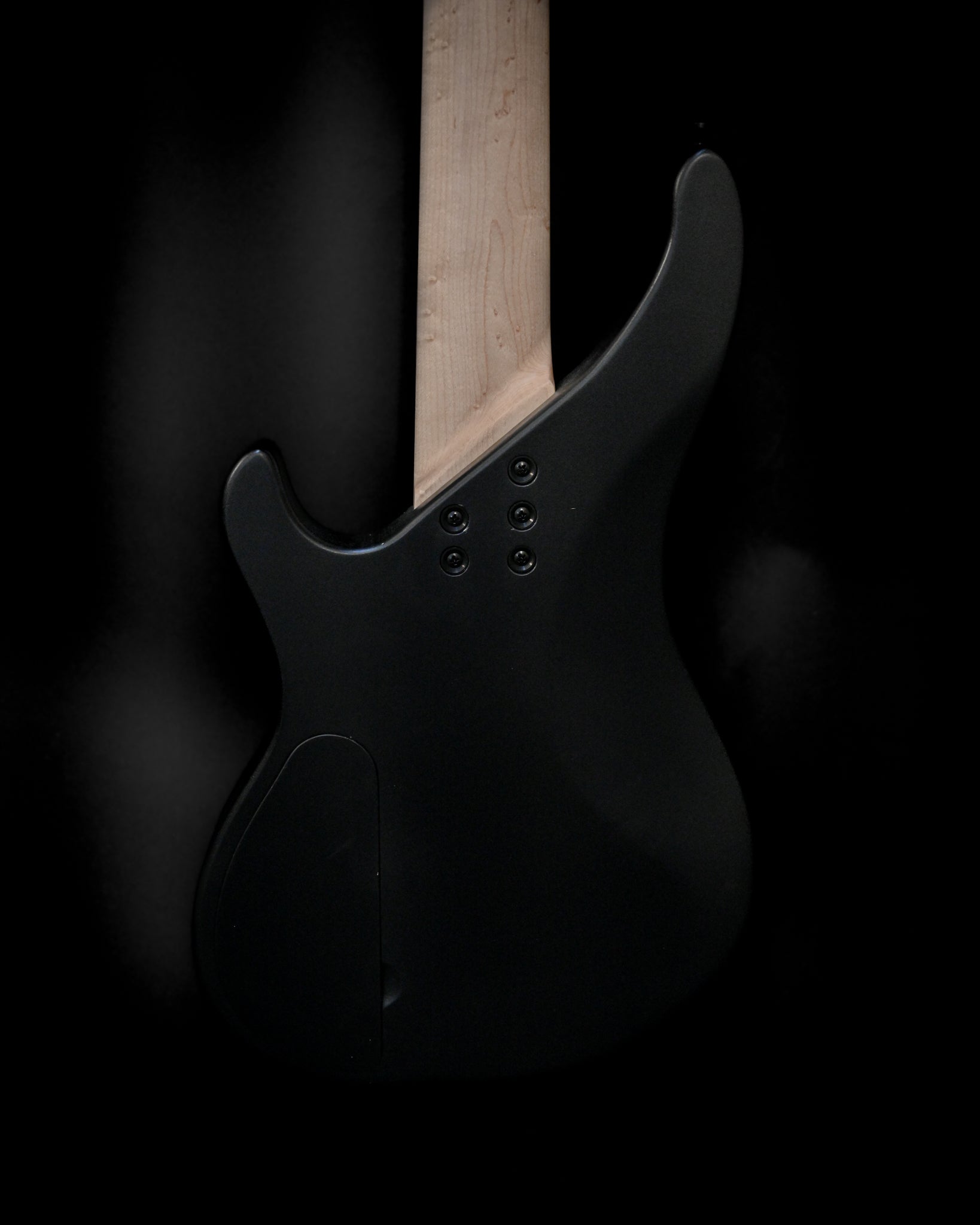 Belforti Instruments E3 Lorraine Coal 低音吉他琴头和琴颈的侧面透视图。